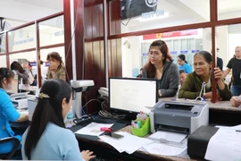 Người dân liên hệ bộ phận một cửa giải quyết các vấn đề liên quan hộ tịch ở phường Nha Trang, tỉnh Khánh Hòa trong ngày làm việc đầu tiên của chính quyền 2 cấp. (Ảnh: Phan Sáu/TTXVN)