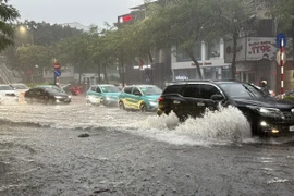 Chỉ sau vài phút mưa tuyến phố Nguyễn Văn Cừ, Long Biên đã ngập úng diện rộng gây ảnh hưởng đến các phương tiện tham gia giao thông. (Ảnh: An Đăng/TTXVN)