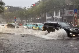 Chỉ sau vài phút mưa tuyến phố Nguyễn Văn Cừ, Long Biên đã ngập úng diện rộng gây ảnh hưởng đến các phương tiện tham gia giao thông. (Ảnh: An Đăng/TTXVN)