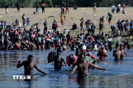 Người di cư vượt sông Rio Bravo ở biên giới Mexico để vào Mỹ. (Ảnh: THX/TTXVN)