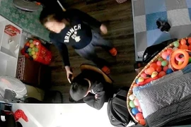 Hình ảnh video thể hiện cảnh được cho là bé trai bị mẹ kế cầm điện thoại đánh vào đầu. (Nguồn: Ảnh cắt từ clip)