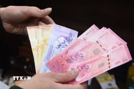 Người dân Syria đổi tiền giấy mới tại thủ đô Damascus, ngày 3/1/2026. (Nguồn: THX/TTXVN)