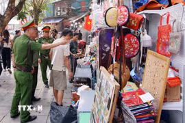 Tổ công tác của Công an phường Hoàn Kiếm xử lý vi phạm về trật tự đô thị tại phố Trần Phú. (Ảnh: Phạm Kiên/TTXVN)
