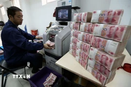 Nhân viên ngân hàng Công thương kiểm đếm đồng nhân dân tệ tại thành phố Vô Tích, tỉnh Giang Tô, Trung Quốc. (Ảnh: THX/TTXVN)