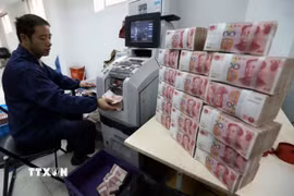 Nhân viên ngân hàng Công thương kiểm đếm đồng nhân dân tệ tại thành phố Vô Tích, tỉnh Giang Tô, Trung Quốc. (Ảnh: THX/TTXVN)