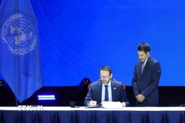 Đại sứ Liên hiệp Vương quốc Anh và Bắc Ireland tại Việt Nam Iain Frew ký Công ước của Liên hợp quốc về Chống tội phạm mạng. (Ảnh: Phương Hoa/TTXVN)