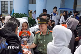 Ban Thanh niên Công an tỉnh An Giang tặng quạt tuyên truyền phòng chống ma túy đến các học sinh. (Ảnh: Văn Sĩ/TTXVN)
