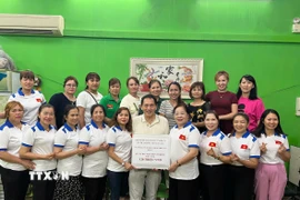 Hiệp hội người Việt Nam ở nước ngoài tại Macau (Trung Quốc) ủng hộ đồng bào vùng lũ lụt. (Nguồn: TTXVN phát)