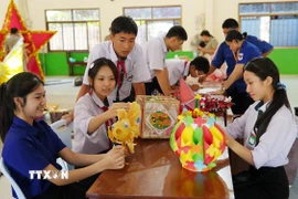 Các em học sinh Việt Nam-Lào háo hức chuẩn bị Tết Trung thu. (Ảnh: Xuân Tú/TTXVN)