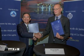 Phó Chủ tịch Ủy ban Nhân dân thành phố Đà Nẵng Trần Nam Hưng và Thị trưởng thành phố Le Havre Édouard Philippe trao đổi Bản ghi nhớ thiết lập quan hệ hợp tác và hữu nghị giữa hai thành phố cảng. (Nguồn: TTXVN phát)