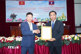 Thiếu tướng Buaphanin Thapanya, Phó Bí thư Tỉnh ủy tỉnh Xaysomboun trao quyết định thành lập Ban quản lý người Việt Nam tại tỉnh Xaysomboun cho ông Hoàng Ngọc Tuyền (trái), Trưởng ban. (Ảnh: Đỗ Bá Thành/TTXVN)