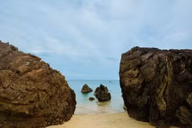 Bãi Đá Nhảy mang vẻ đẹp nguyên sơ với nước biển trong xanh, bờ cát vàng và những dãy đá nối tiếp nhau ra tận mép sóng. (Nguồn: Vietnam+)