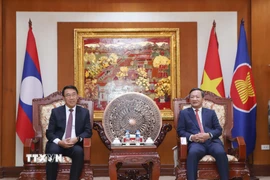 Đại sứ Việt Nam tại Lào Nguyễn Minh Tâm (phải) tiếp Ủy viên Trung ương Đảng, Trưởng Ban Đối ngoại Trung ương Lào Bounleua Phandanouvong đến chúc mừng. (Ảnh: Xuân Tú/TTXVN)