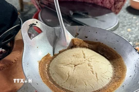 Bánh được nướng trên khuôn gang truyền thống, tỏa hương thơm hấp dẫn. (Ảnh: Thanh Sang/TTXVN)
