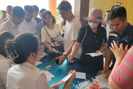 Người dân làm thủ tục trước khi bước vào phiên đấu giá đất tại xã Đình Dù, Văn Lâm (Hưng Yên). (Ảnh: Mạnh Khánh/TTXVN)