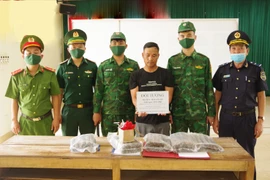 Đối tượng Mai Văn Kỳ cùng tang vật bị bắt giữ. (Ảnh: TTXVN phát)