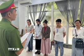 Lực lượng chức năng đọc lệnh Khởi tố tại việc Phòng khám Đa khoa Quốc tế Đà Nẵng. (Nguồn: TTXVN phát)