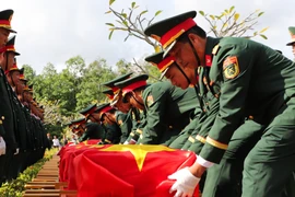 Đội tiêu binh thực hiện nghi thức an táng liệt sỹ. (Ảnh: Hồng Thái/TTXVN)