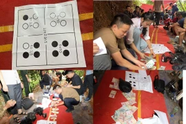 Các đối tượng đánh bạc và tang vật thu giữ tại hiện trường. (Ảnh: TTXVN phát)