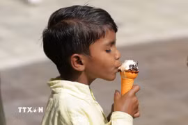 Em nhỏ ăn kem giải nhiệt trong ngày nắng nóng tại Amritsar, bang Punjab, Ấn Độ. (Nguồn: THX/TTXVN)