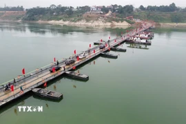 Người và phương tiện lưu thông bình thường qua cầu phao sông Lô sáng 16/2. (Ảnh: Nguyễn Văn Cảnh/TTXVN)