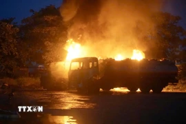 Tại hiện trường, xe bồn chở xăng dầu đang bốc cháy nghi ngút. (Ảnh: Quốc Dũng/TTXVN)
