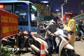 Cán bộ, chiến sỹ cảnh sát giao thông kiểm tra đồng nồng độ cồn với người tham gia giao thông. (Ảnh: Phạm Kiên/TTXVN)