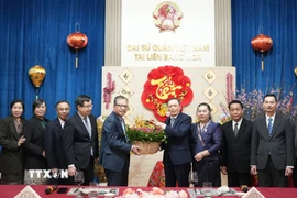 Đại sứ Việt Nam Đặng Minh Khôi và Đại sứ Lào Shiphandone Oybuabuddy cùng cán bộ, nhân viên hai Đại sứ quán hai nước. (Ảnh: Trần Hải/TTXVN)