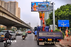 Lực lượng chức năng và đơn vị thi công kiểm tra, hoàn thiện hệ thống bảng thông tin giao thông điện tử trước khi đưa vào vận hành. (Ảnh: Trung Nguyên/TTXVN)