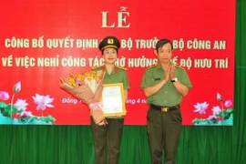 Thiếu tướng Huỳnh Văn Hải, Phó Cục trưởng Cục Tổ chức cán bộ trao Quyết định của Bộ trưởng Bộ Công an cho Đại tá Võ Thị Hoài Ngọc. (Ảnh: TTXVN phát)