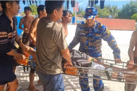 Ngư dân tàu cá QN 95489-TS đưa anh Phạm Văn Minh vào đảo Sinh Tồn cấp cứu. (Ảnh: TTXVN phát)