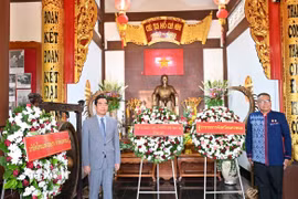Đại sứ Phạm Việt Hùng (trái) và Tỉnh trưởng tỉnh Nakhon Phanom Adisak Noisuwan dâng hoa kỷ niệm Ngày sinh nhật Bác. (Ảnh: Đỗ Sinh/TTXVN)
