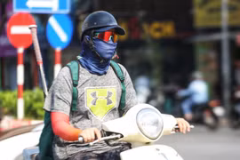 Người dân ra đường ngày nắng nóng thường bịt kín để đảm bảo sức khỏe. (Ảnh: Thu Phương/TTXVN phát)