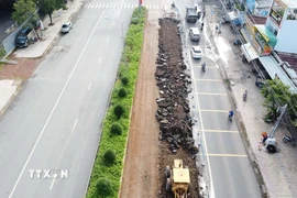 Cơ quan chức năng đang tiến hành sửa chữa trên quốc lộ 14, đoạn qua phường Bình Phước. (Ảnh: Đậu Tất Thành/TTXVN)