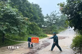 Chính quyền xã Lao Bảo (Quảng Trị) cắt cử lực lượng ứng trực, cắm biển cảnh bảo tại khu vực ngập sâu. (Ảnh: TTXVN phát)