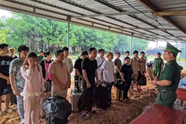 Lực lượng Đồn Biên phòng Cửa khẩu quốc tế Mộc Bài tiếp nhận các công dân Việt Nam tại khu vực Cửa khẩu quốc tế Mộc Bài. (Ảnh: TTXVN phát)