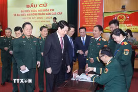 Chủ tịch nước Lương Cường nhận thẻ cử tri đã đóng dấu xác nhận bỏ phiếu tại khu vực bỏ phiếu số 26, phường Hoàn Kiếm, thành phố Hà Nội. (Ảnh: Lâm Khánh/TTXVN)
