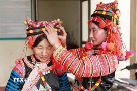 Phụ nữ người Hà Nhì vùng biên viễn Lai Châu sửa soạn trang phục đón một mùa Xuân mới. (Ảnh: Quý Trung/TTXVN)
