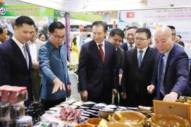Lãnh đạo thương mại Việt Nam, Lào và các đại biểu tham quan gian hàng của Việt Nam tại Hội chợ. (Ảnh: Xuân Tú/TTXVN)