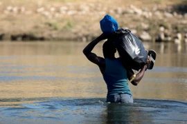 Người di cư vượt sông Rio Grande ở biên giới Mỹ-Mexico. (Ảnh: THX/TTXVN)