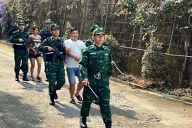 Bội đội biên phòng áp giải 2 đối tượng mua bán người trong chuyên án. (Ảnh: TTXVN phát)