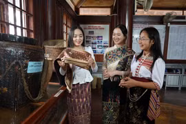 Em Bounsana Thidasavanh và các bạn tìm hiểu văn hóa truyền thống của Việt-Lào. (Ảnh: Bích Huệ/TTXVN)