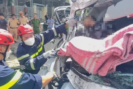Lực lượng cứu nạn đưa thi thể nạn nhân ra ngoài. (Ảnh: TTXVN phát)