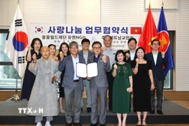 Bà Nguyễn Thị Thái Bình, Tham tán Công sứ (người thứ hai, hàng đầu, từ phải sang) chứng kiến lễ ký bản ghi nhớ. (Ảnh: Đức Thắng/TTXVN)