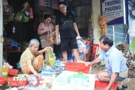 Người dân phường Tây Nha Trang, tỉnh Khánh Hòa lau dọn những nhu yếu phẩm còn sử dụng được sau ngập lụt. (Ảnh: Phan Sáu/TTXVN)