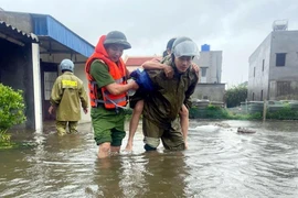 Công an xã Hải Thịnh, Ninh Bình huy động khoảng 30 cán bộ, phối hợp với chính quyền địa phương hỗ trợ người dân đến nơi an toàn. (Ảnh: Thái Thuần/TTXVN)
