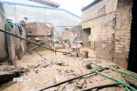 Nhân dân xã Chiềng Sơ (tỉnh Sơn La) san gạt bùn. (Ảnh: Quang Quyết/TTXVN)