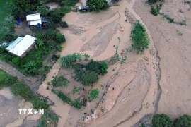 Lực lượng chức năng đã bố trí người cắm thiết bị cảnh bảo ở các điểm sạt lở cho các phương tiện giao thông đi qua. (Ảnh: Văn Tý/TTXVN)