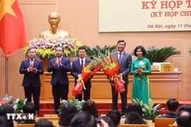 Lãnh đạo thành phố Hà Nội tặng hoa, chúc mừng tân Phó Chủ tịch Ủy ban Nhân dân thành phố Hà Nội Đỗ Anh Tuấn và Bùi Duy Cường. (Ảnh: Văn Điệp/TTXVN)