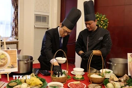 Quan chức ngoại giao tại Trung Quốc trải nghiệm cách chế biến một tô phở. (Ảnh: Hải Yến/TTXVN)